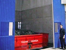 Dust enclosure for shakeout with powered doors and roof access for crane